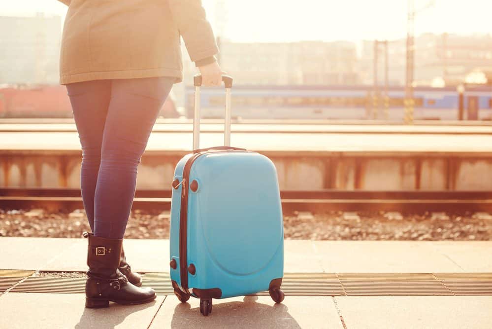 Newark Airport to Manhattan Woman waiting for the train with her suitcase
