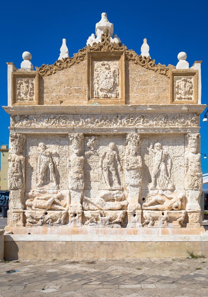 The greek fountain is located in Gallipoli, Italy near the bridge that connects the new town to the old town. 